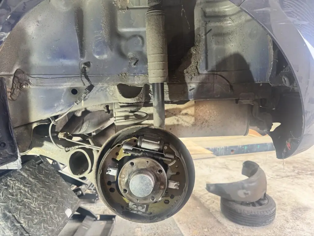 Rear drum brake shoes and shock absorber exposed on a car on the lift at our Royston workshop